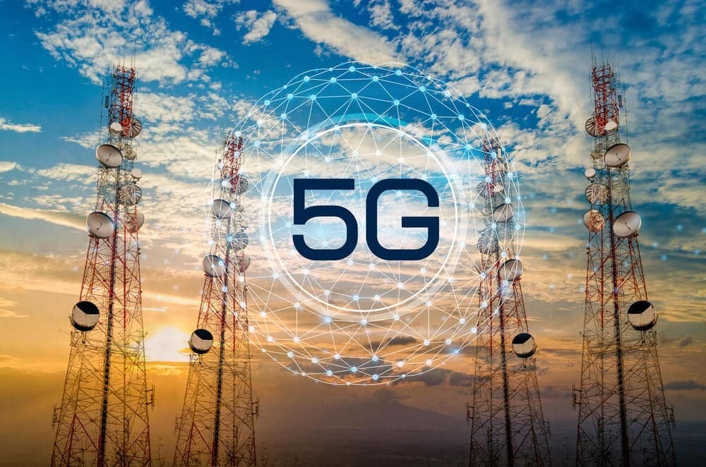 Телекоммуникационные башни 5G с радиосигналами и ярким небом на заднем плане.