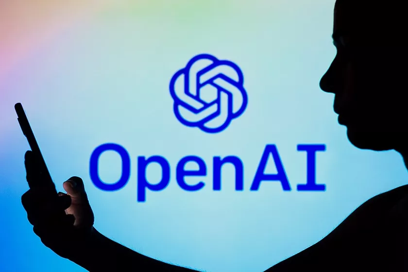 Силуэт человека с телефоном на фоне логотипа OpenAI