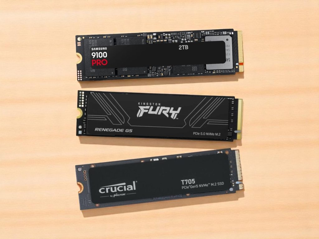 Три высокопроизводительных NVMe M.2 твердотельных накопителя от Samsung, Kingston и Crucial на деревянной поверхности