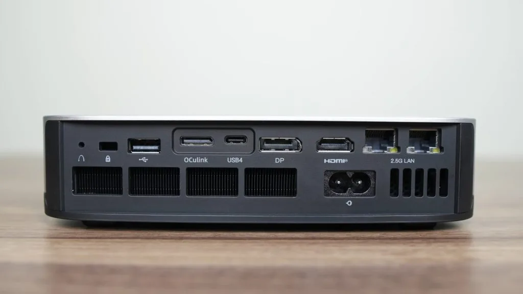 Задний вид компактного ПК Minisforum AI X1 Pro, демонстрирующий различные варианты подключения, включая порты USB, HDMI и Ethernet.