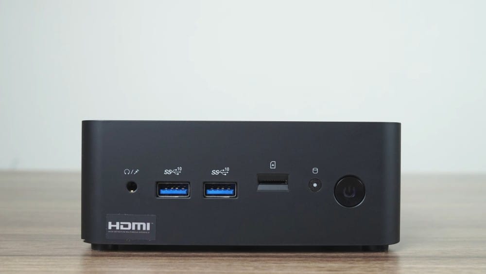 Компактный черный мини-ПК с несколькими USB-портами, HDMI-входом и аудиоджеком, идеален для домашнего или офисного использования.