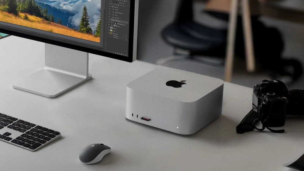 Обзор Mac Studio M3 Ultra: абсолютная мощь, но для кого?Современная рабочая станция с настольным компьютером Apple Mac studio, монитором, клавиатурой и камерой на стильном столе.